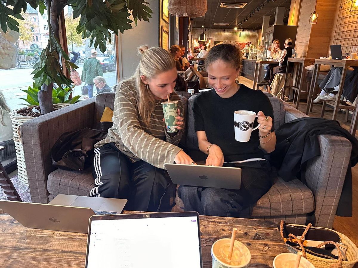 To studerende griner og kigger på en computer